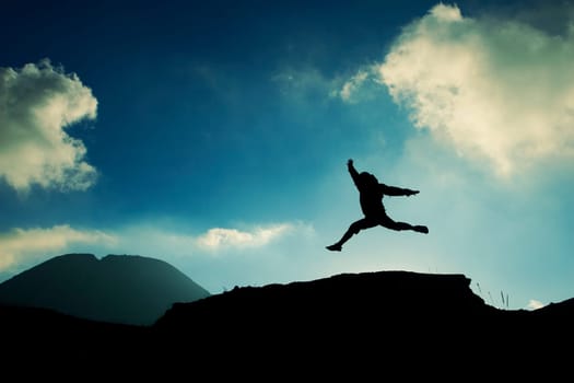 a man jumping on top of a rock