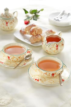 Two cups of tea with small sweet rolls
