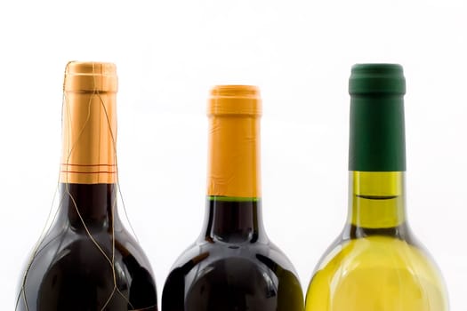 the top of three wine bottles on a white background
