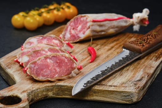 Slices of cured sausage on cutting board