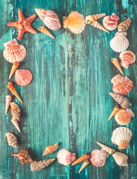 Seashell and star fish frame on rustic wooden texture background design with copyspace. Summer holiday and tropical beach travel concept. Retro filter.