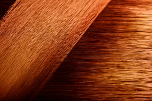 Perfect healthy dyed red hair sample. Color hairstyle palette swatches. Orange hair texture background.