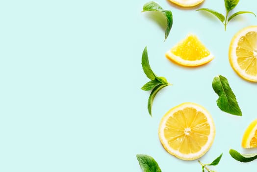 Top view of citrus slices and mint herbs frame on retro mint background with copyspace