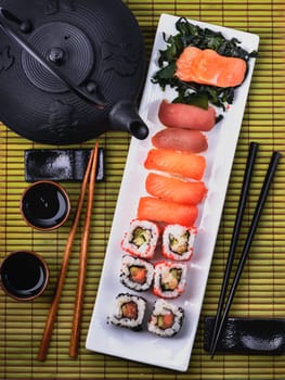 Top view of traditional japanese cuisine. Sushi set with salmon and tuna fish with chopsticks from above.