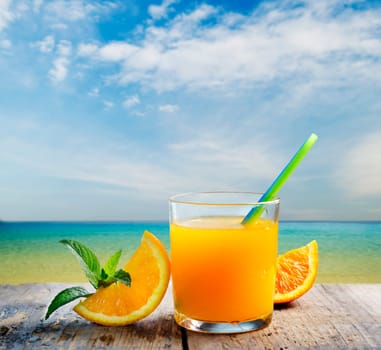 Orange juice vodka cocktail on tropical sandy beach. Summer holiday and beach party design.