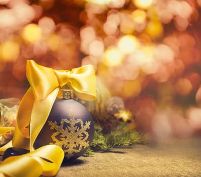 Christmas ornaments and pine tree over shiny blur lights background with copyspace. Christmas and new year holiday design.