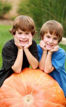 Two Boys Resting on a Huge Pumpkin