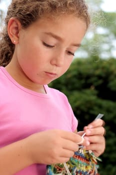 Cute girl knitting. Motion blur on hand.