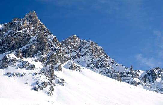 snowed mountainrange with visible rocks