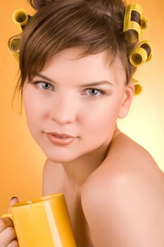 girl with hair-rollers holding a coffee cup