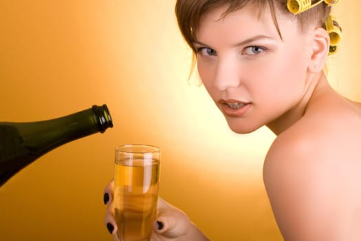 girl with hair-rollers holding a glass of wine