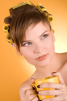 girl with hair-rollers holding a coffee cup