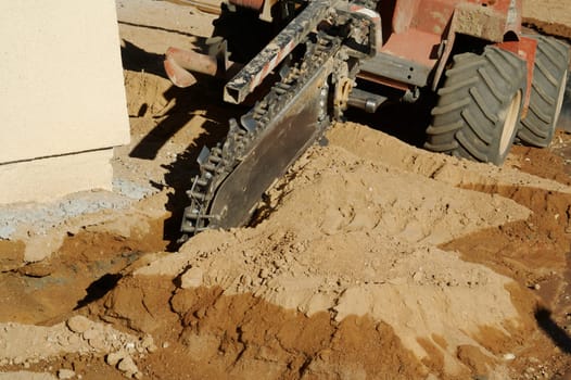 Mini trench digging machinery prepares for new home irrigation system.
