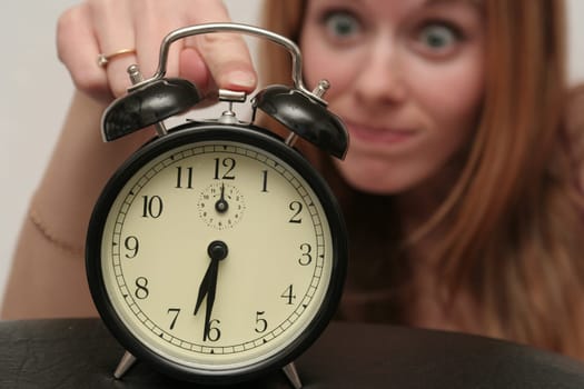 The black alarm clock has woken the girl
