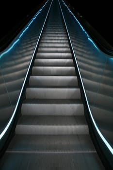 An escalator going up with colored stripes on both sides