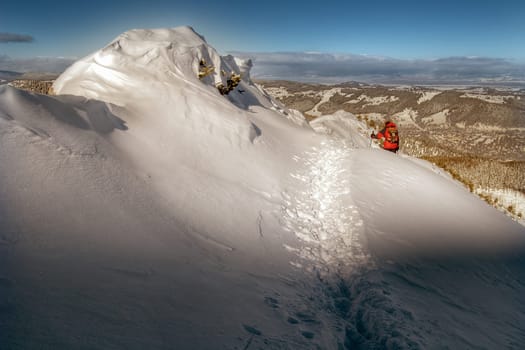 A man walking on the snow covered slope.