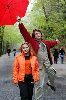 Romantic couple having a good time in a park on a rainy day
