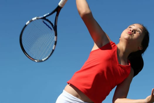 Girl playing tennis against the sky