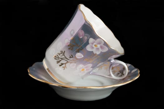 porcelain cup and saucer on a black background