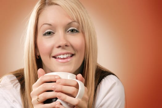 Happy and smiling female drinking coffee in an urban café.