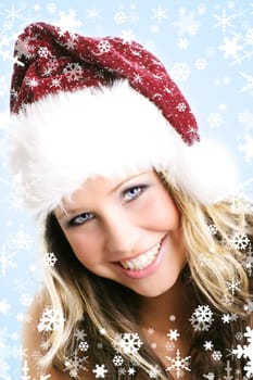 winter portrait of a young smiling woman with a christmas cap and snowflakes