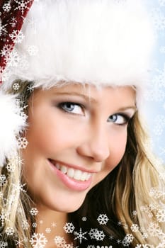 winter portrait of a young smiling woman with a christmas cap and snowflakes