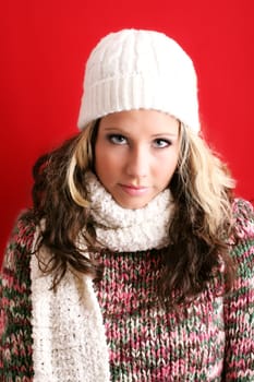 winter portrait of a beautiful young woman is freezing with a cap and a scarf