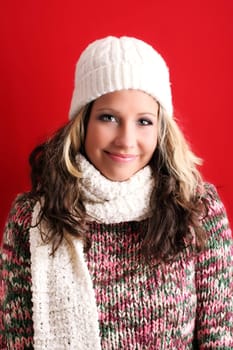 winter portrait of a beautiful young woman is freezing with a cap and a scarf