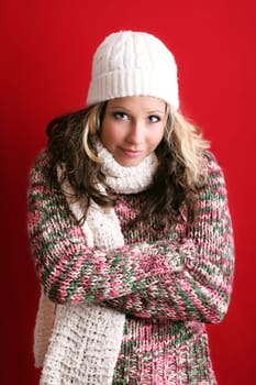 winter portrait of a beautiful young woman is freezing with a cap and a scarf