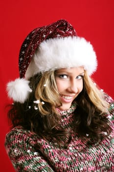 winter portrait of a beautiful young smiling woman with a christmas cap