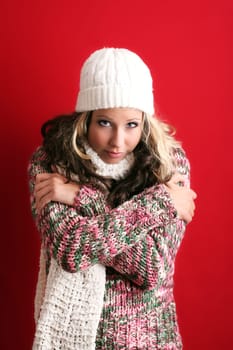 winter portrait of a beautiful young woman is freezing with a cap and a scarf