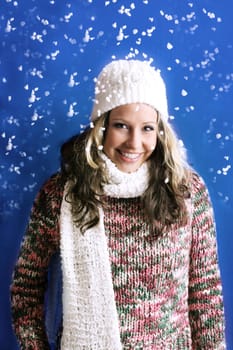 winter portrait of a beautiful woman is freezing with a cap and a scarf and snowflakes