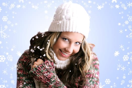 winter portrait of a beautiful woman is freezing with a cap and a scarf and snowflakes