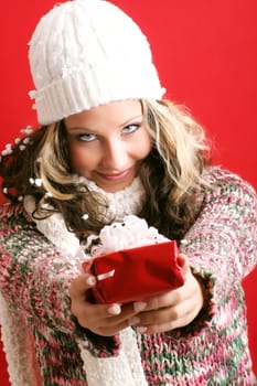winter portrait of a beautiful young smiling woman with a gift in her hands