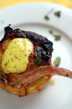 Pan fried pork cutlet on a tomato capsicum cous-cous with lime aioli (lime, olive oil, and egg) coriander garnish.