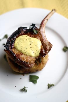 Pan fried pork cutlet on a tomato capsicum cous-cous with lime aioli (lime, olive oil, and egg) coriander garnish.