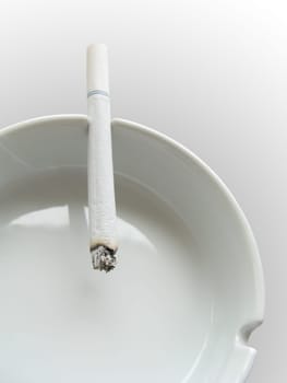 close photo of cigarette and ashtray on white background