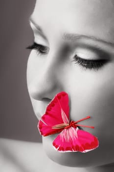 beauty portrait of a beautiful young woman with a butterfly on her lips