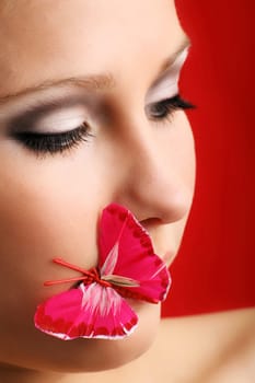 beauty portrait of a beautiful young woman with a butterfly on her lips