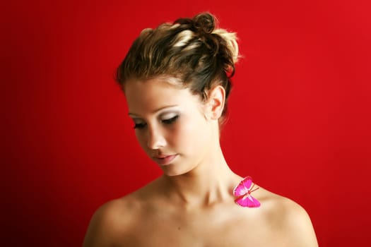 beauty portrait of a beautiful young woman with a butterfly on her shoulder