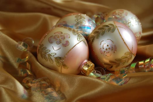 Christmas ornaments and ribbon on gold satin.