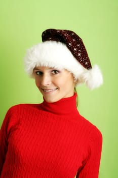 winter portrait of a beautiful young smiling woman with a christmas cap