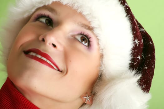 winter portrait of a beautiful young smiling woman with a christmas cap