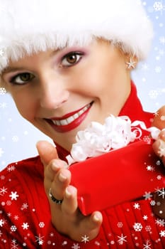 winter portrait of a smiling woman with a gift in her hands and snowflakes