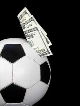 Soccer ball on black with money stuck in it.