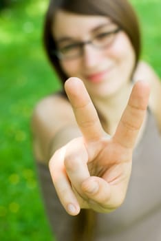 young smiling woman making victory gesture