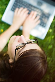 portrait of young woman surfing the internet outdoors on her notebook