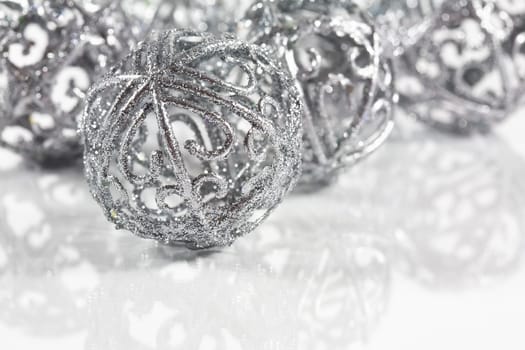 Silver balls on white background with small reflection