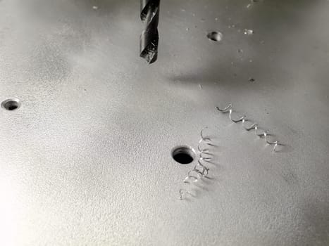 drilling holes, flat metallic board with spokeshaves and drill