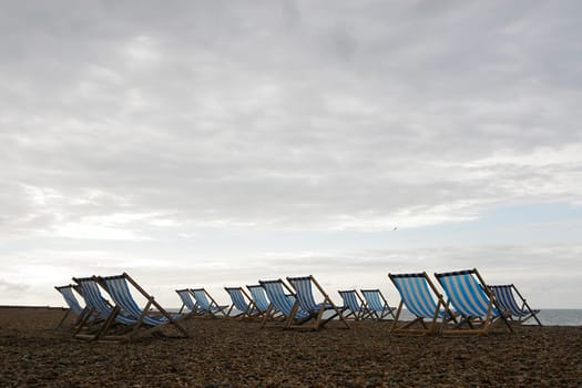 Deck chairs set out on an English beach just waiting for the sun